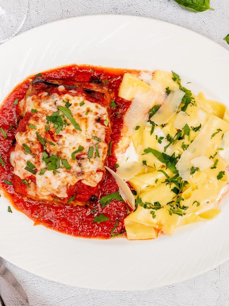 Eggplant parmigiana in marinara under melted mozzarella, with pappardelle alfredo on the side