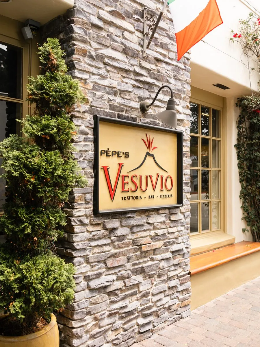 The Pèpe's Vesuvio sign on the stone wall at the entrance, Italian flag above