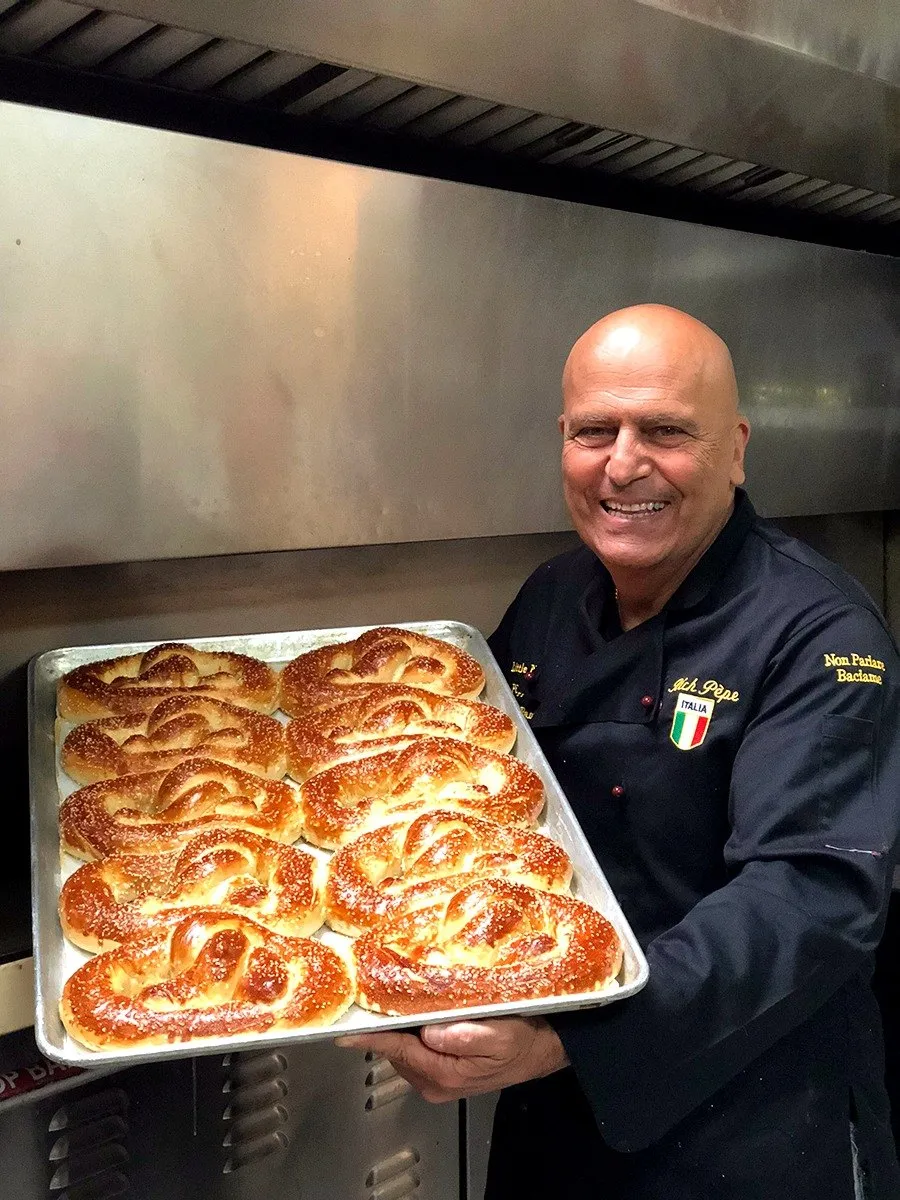 Chef Pèpe holding a tray of fresh pretzels