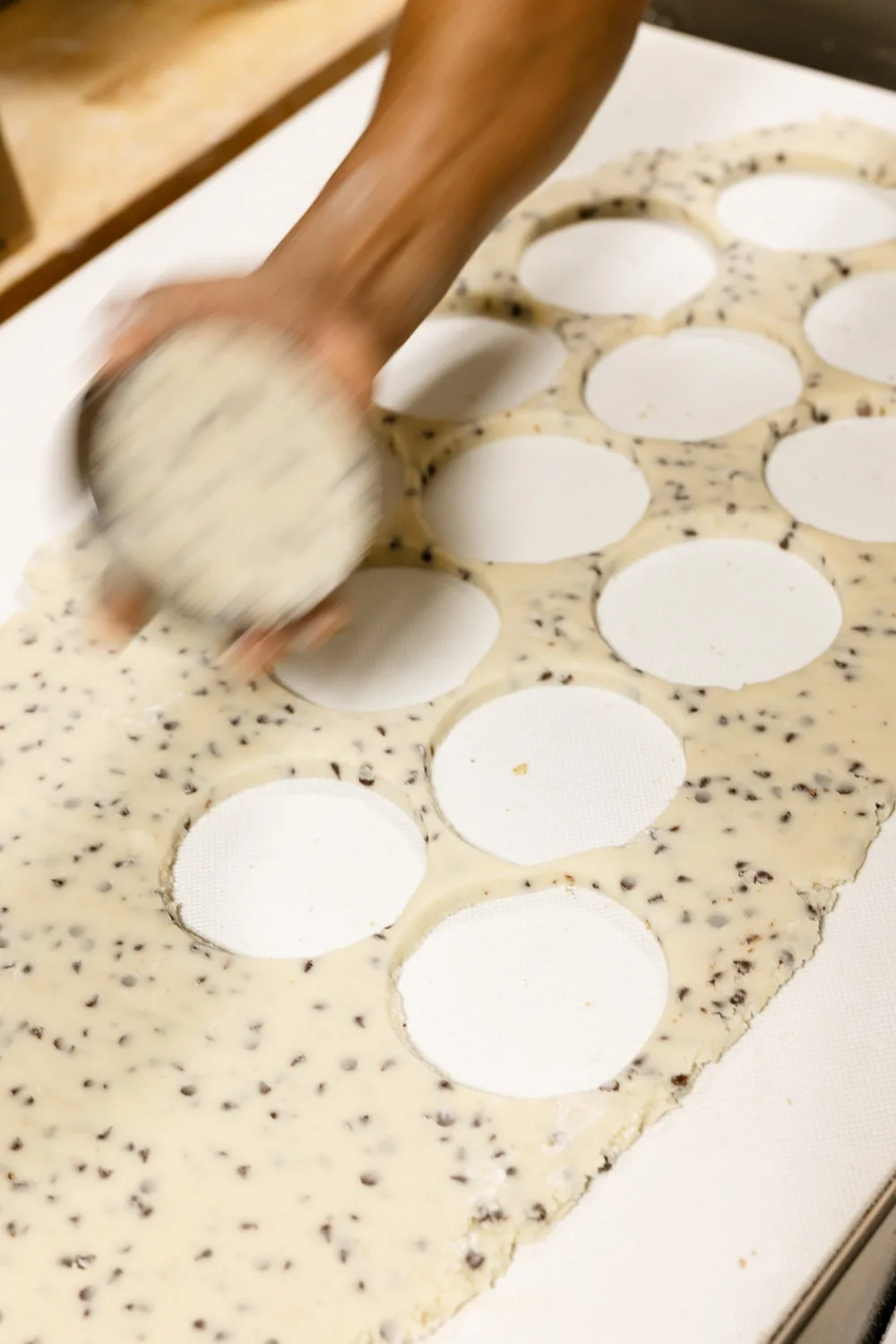 The round cookie cutter on a sheet of cookie dough