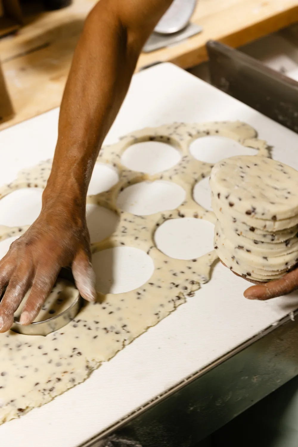 Hands pressing out rounds of cookie dough