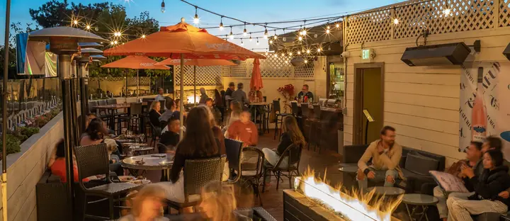 Guests at The Starlight Lounge at Vesuvio, the rooftop bar, at dusk.
