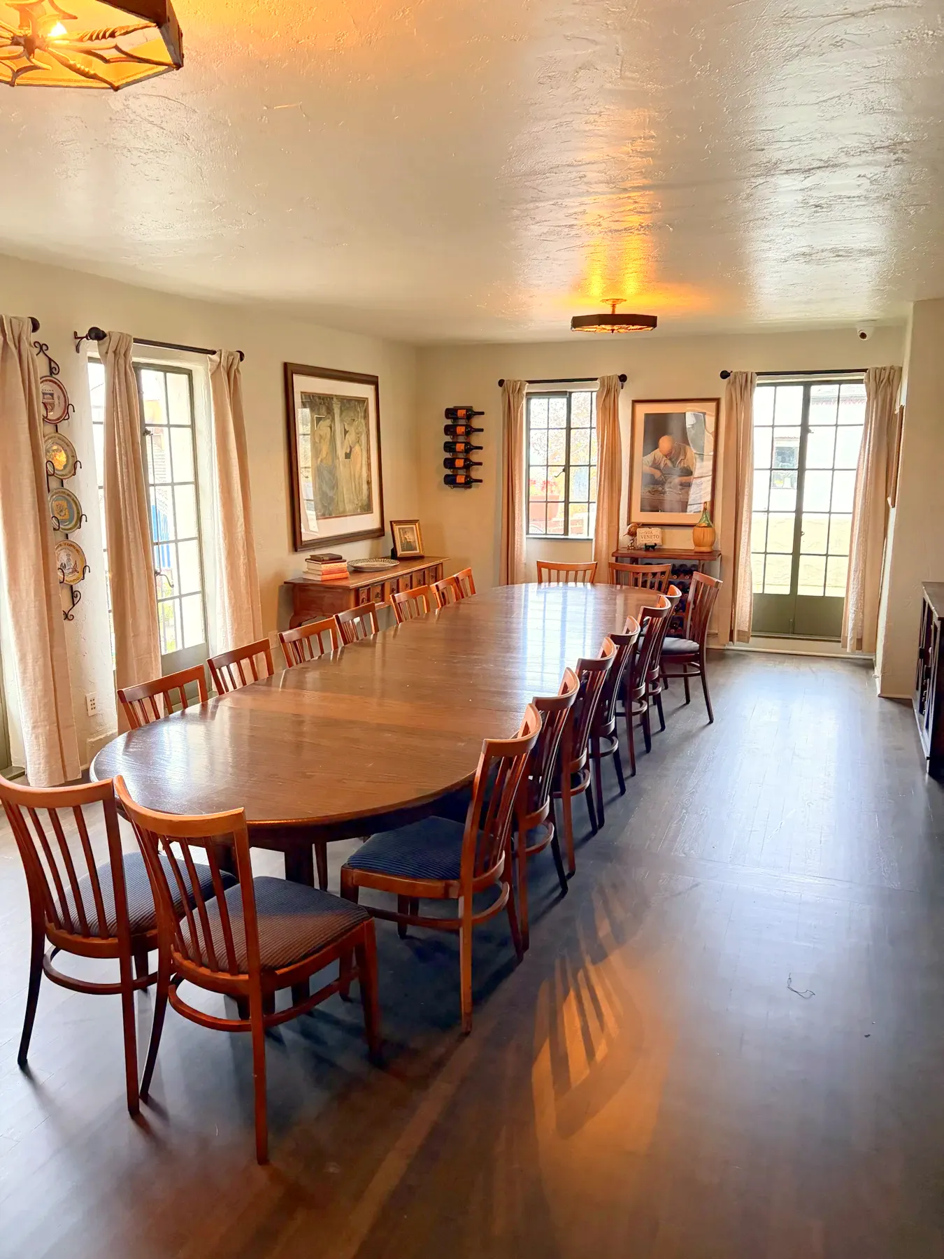 La Dolce Vita, the redesigned private dining room at Little Napoli: one long wood table with chairs down both sides, tall windows and framed art